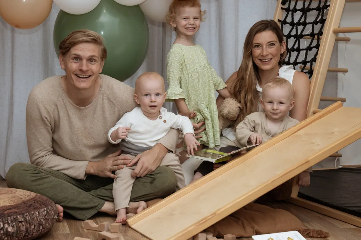 Familie mit drei Kindern vor Luftballons