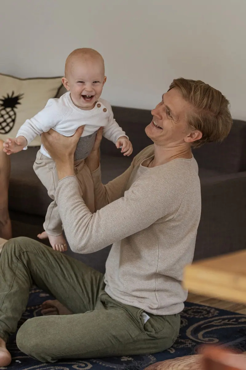Vater hebt sein lachendes Baby hoch