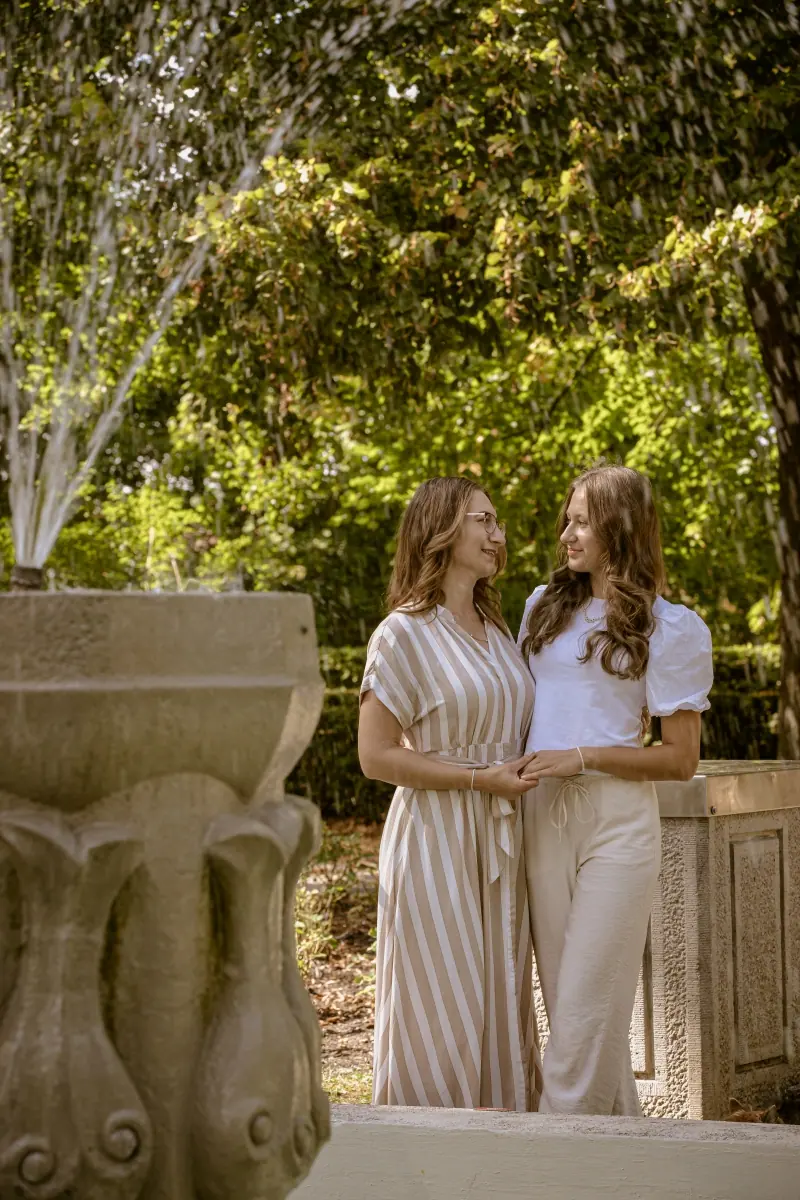 Zwei Frauen an einer Steinsäule im Park