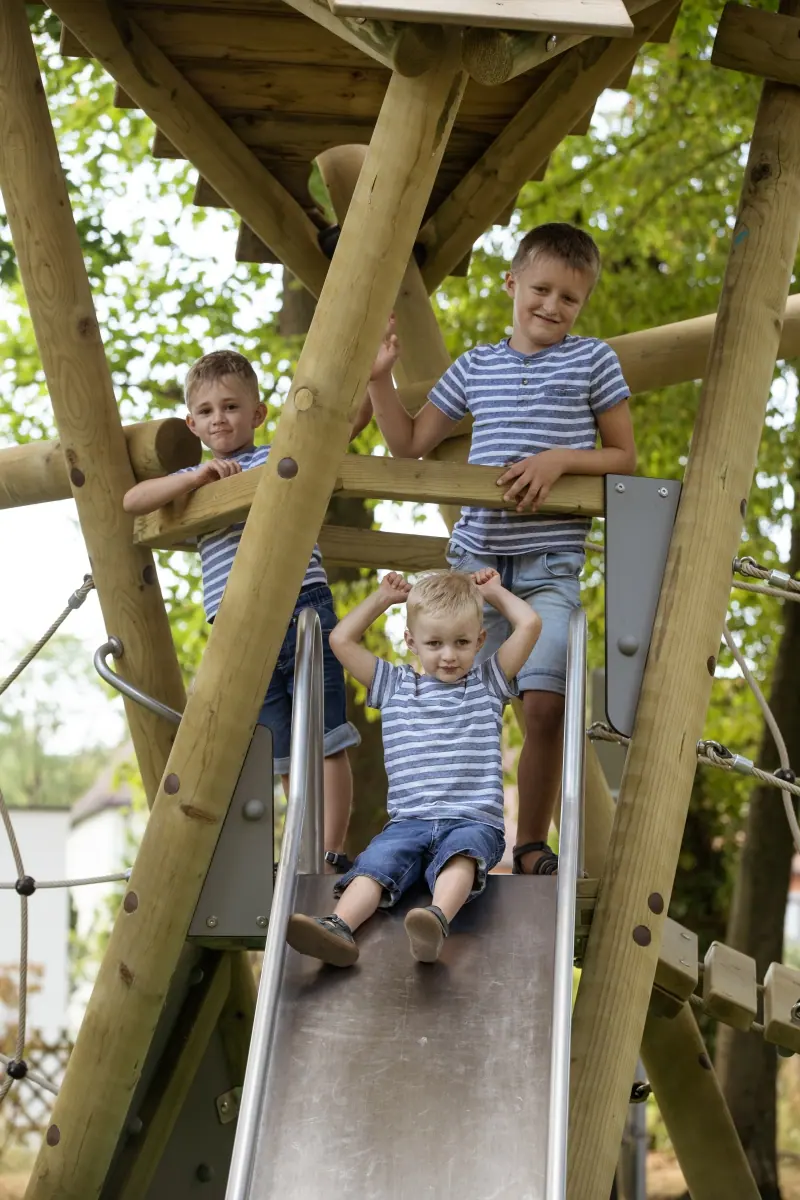 Vater mit zwei Jungen an der Rutsche