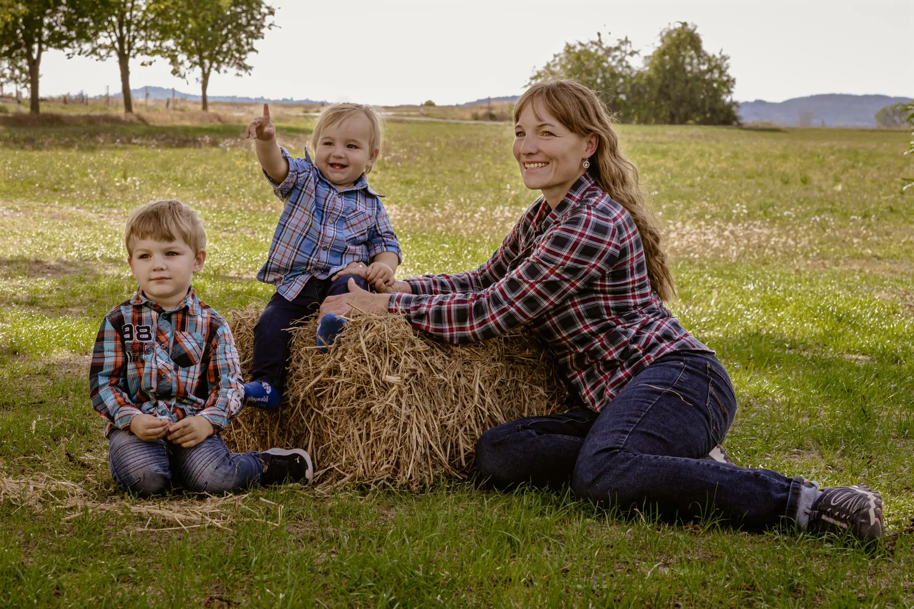 Mutter mit zwei Jungen an einem Strohballen – Familien-Fotoshooting