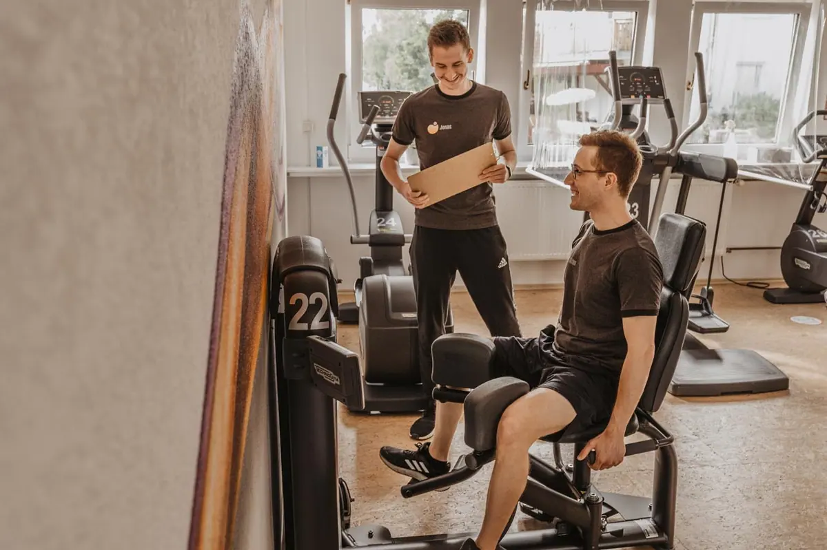 Trainer weist einen Kunden am Ergometer ein